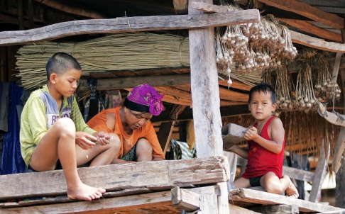 An Akha mother and her children in their house in a hill village in northwestern Laos. At the bottom of the opium supply chain, the Akha gain little from it.