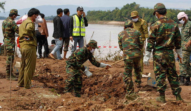 Soldiers survey the crash site of an ATR-72 turboprop plane, in Laos, near Pakse, on Thursday