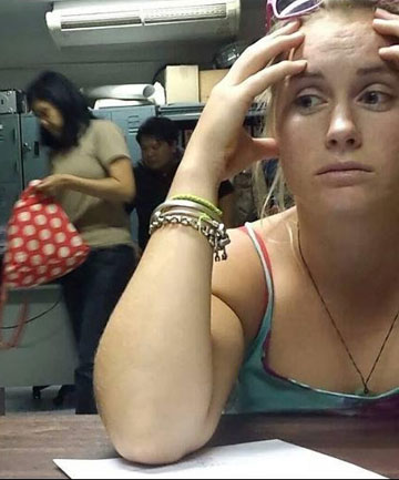 ANXIOUS WAIT- Kiwi tourist Casey Hanson, 21, sits in a Thai police station after being caught in possession of counterfeit US American currency.