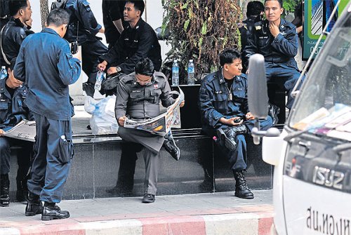 Centre of the controversy: Police take a break outside Thong Lor station. Officers from the station have recently come under scrutiny for their stop-and-search tactics.